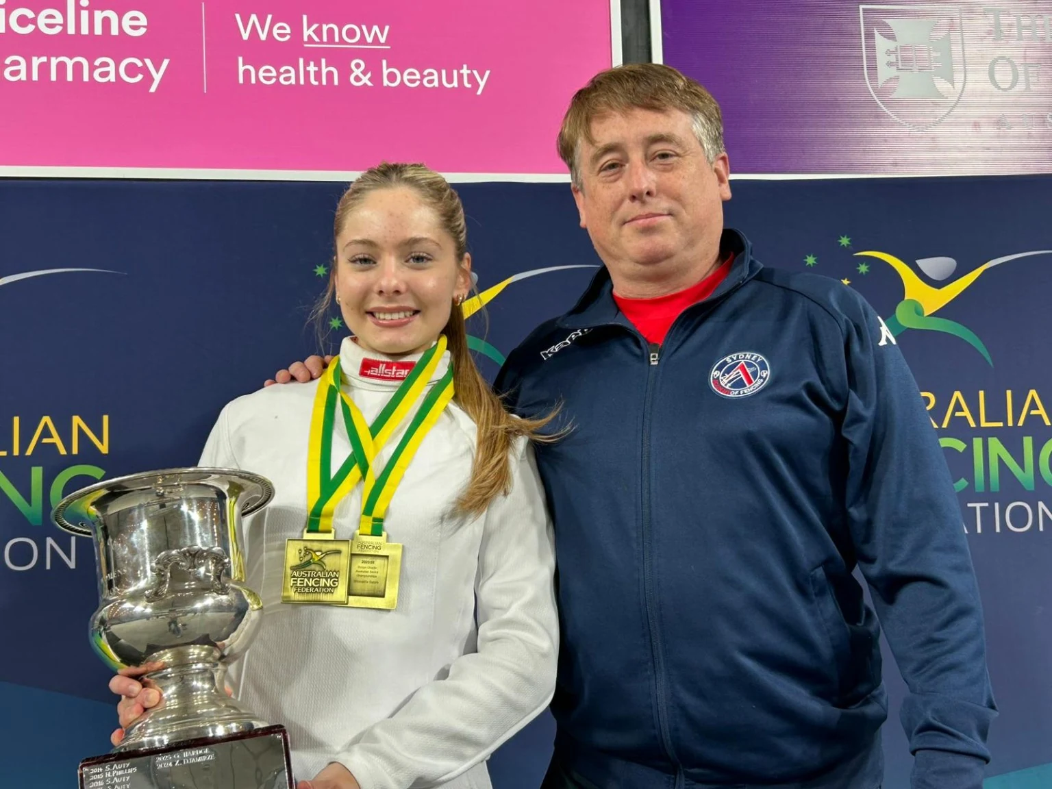 Zara with a coach, two gold medals and a silver trophy